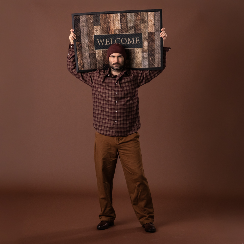 Man holding a wood pattern door mat