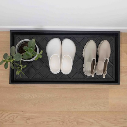 Black Boot tray with shoes and plants on it 