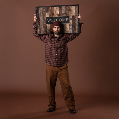 Man holding a wood pattern door mat 