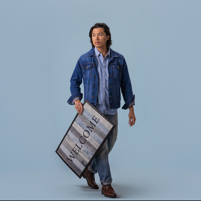 Man holding a blue door mat 